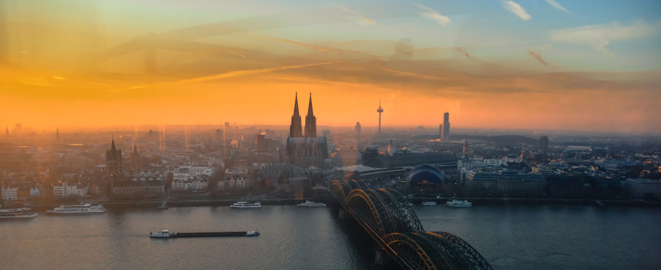 Vista de Colônia, na Alemanha, com a catedral e a ponte Hohenzollern ao amanhecer