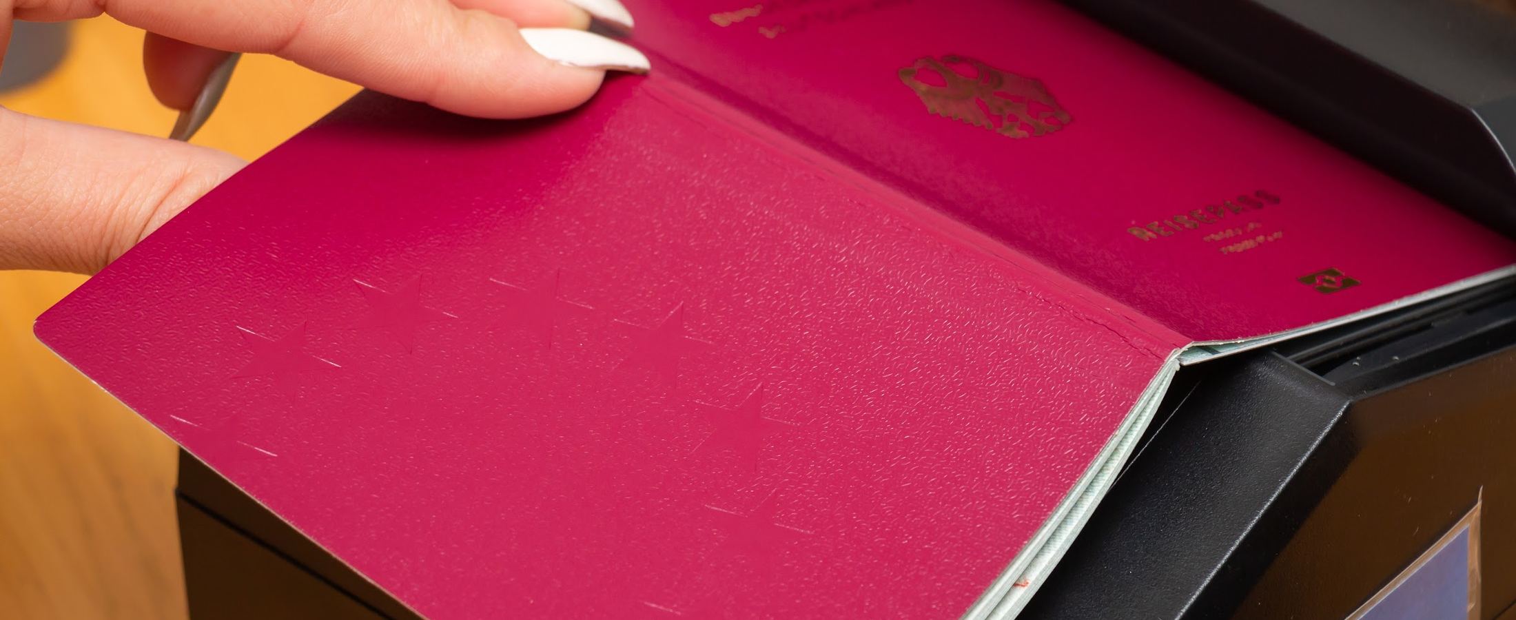 Mãos folheando as páginas de um passaporte alemão