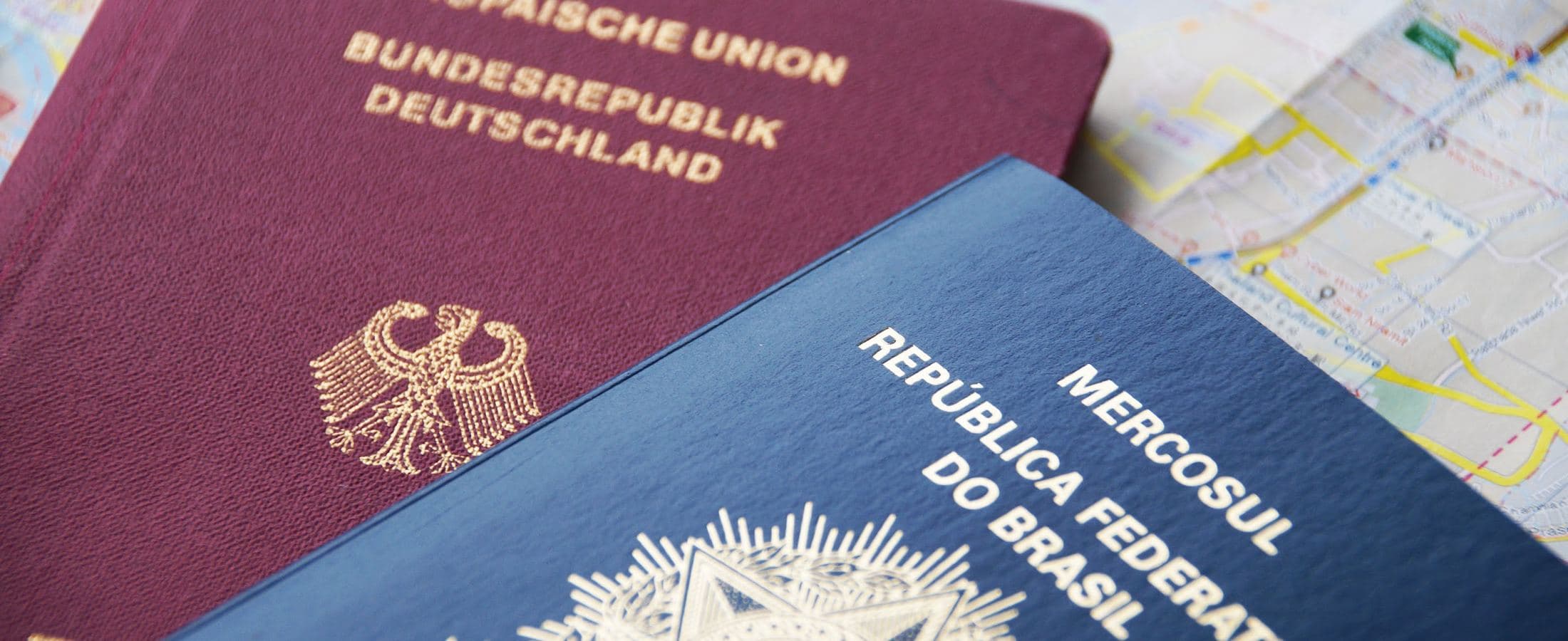 Passaportes alemão e brasileiro sobre um mapa