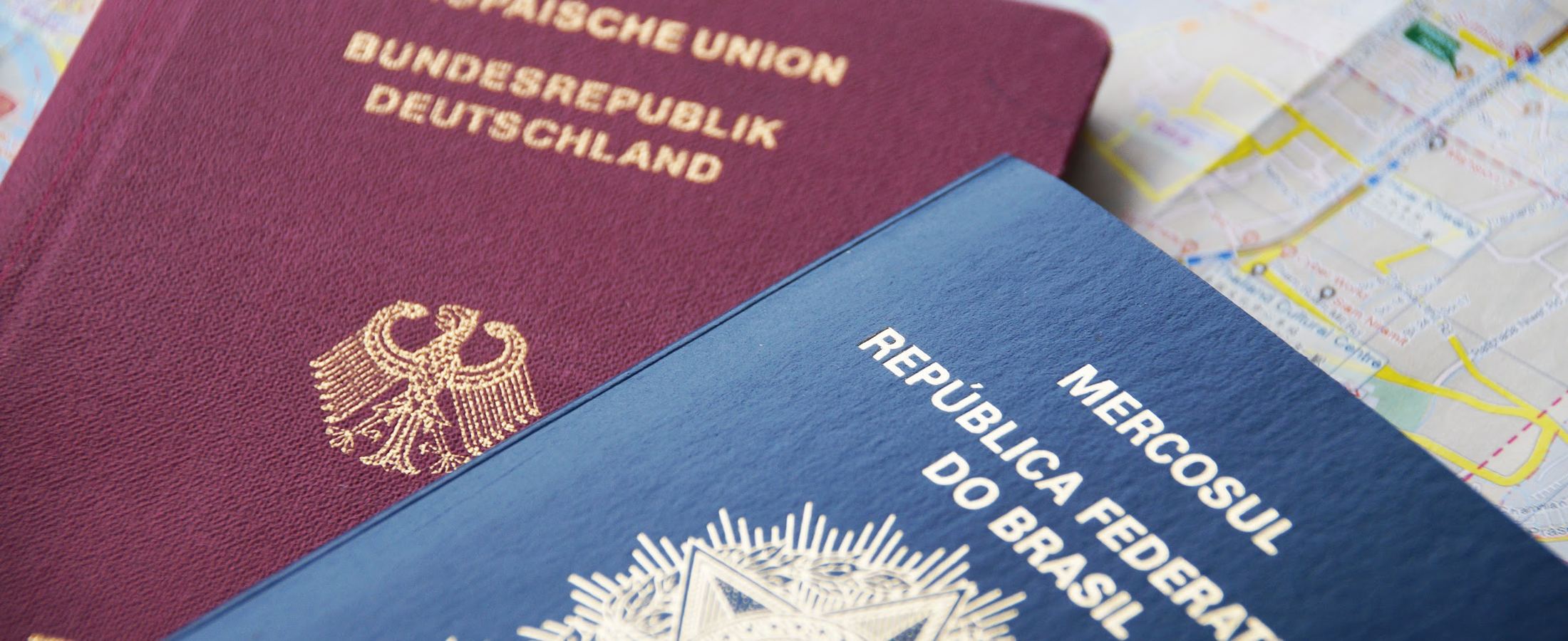 Passaportes alemão e brasileiro sobre um mapa